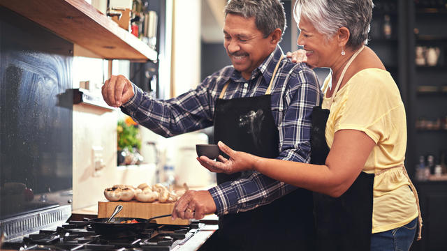 Sprinkles of seasoning: Shot of a happy senior couple cooking together 