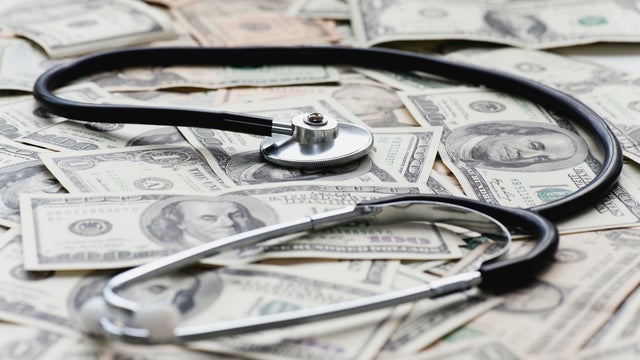 Stethscope on pile of US banknotes 