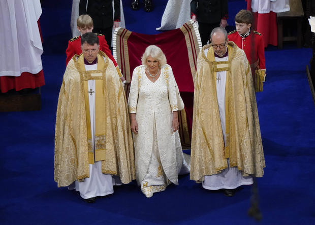 Queen Camilla arrives for her coronation in a long white gown and robe 