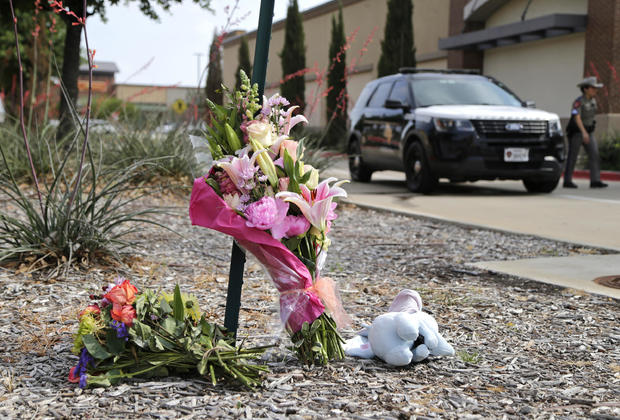 Flowers and a stuffed animal are left at the scene the day after a shooting at Allen Premium Outlets on May 7, 2023 in Allen, Texas. 
