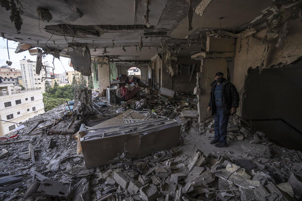 A Palestinian man inspects damage to his building following Israeli airstrikes on an apartment of an Islamic Jihad commander in Gaza City, May 9, 2023