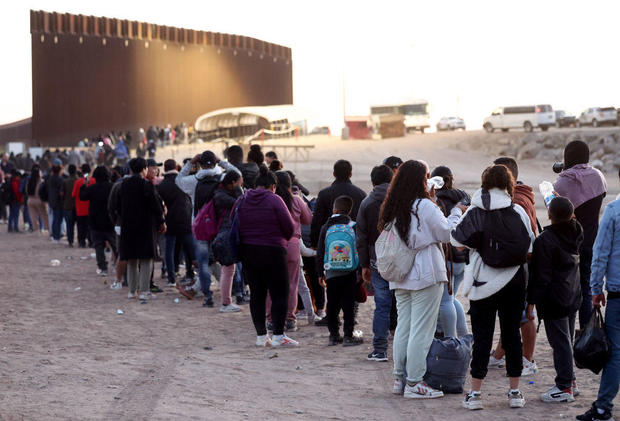 Immigrants seeking asylum in the U.S. wait in line to be processed by U.S. Border Patrol agents after crossing into Arizona from Mexico on May 11, 2023, in Yuma, Arizona. 