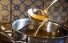 Broth being ladled from saucepan 