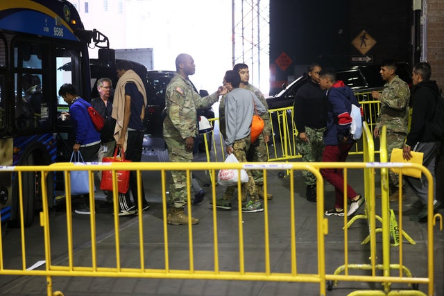 Asylum-seekers board a bus en route to a shelter at Port Authority Bus Terminal on May 18, 2023, in New York City. 