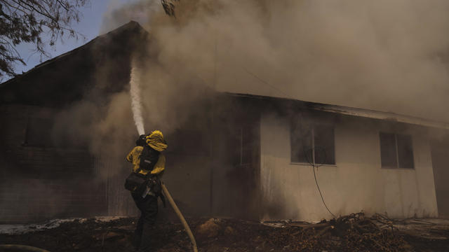 Firefighter works to save a home in Hemet, California 