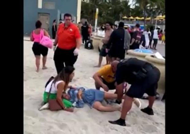 A police officer tends to a victim of the shooting in Hollywood, Florida, on May 29, 2023. 