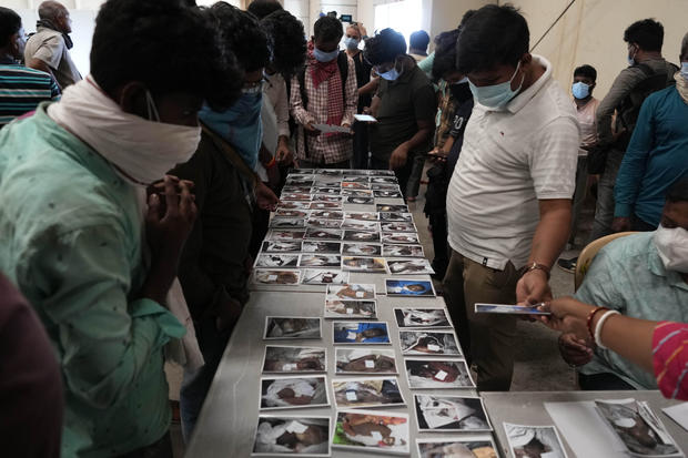 People look at the photographs of the passengers who were traveling in the trains that got derailed for identification in Balasore district, in the eastern Indian state of Orissa, June 4, 2023. 