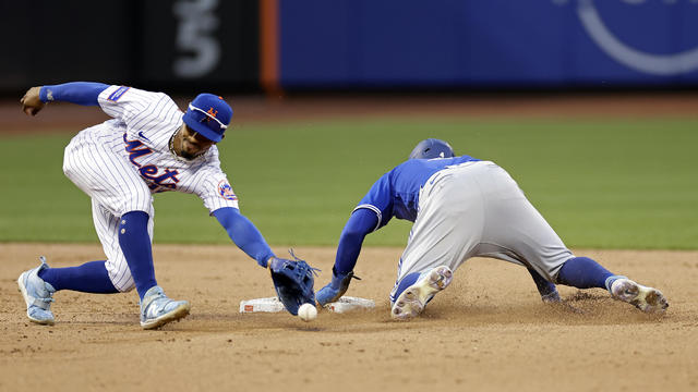 Francisco Lindor (L) #12 of the New York Mets can't handle the throw as George Springer #4 of the Toronto Blue Jays slides to steal second base during the ninth inning at Citi Field on June 3, 2023 in the Queens borough of New York City. 