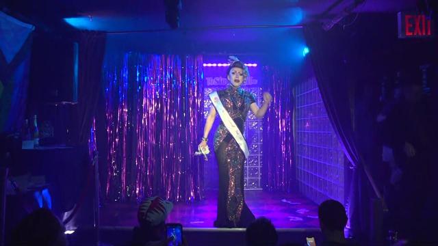 A contestant in the Miss Stonewall pageant stands on stage at the Stonewall Inn. 