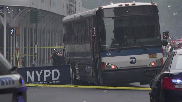 An MTA bus sits on a New York City street behind crime scene tape. 