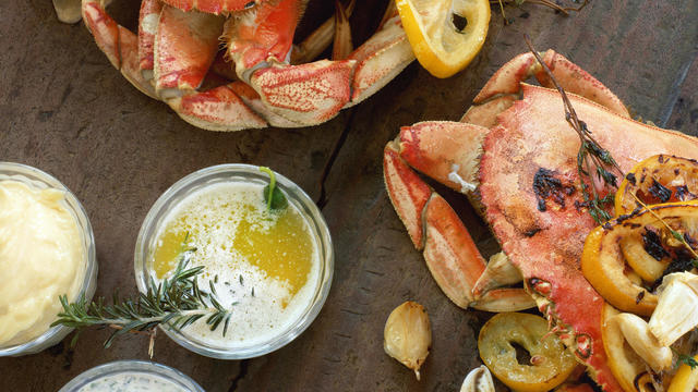 Fire roasted dungeness crabs on wooden table 