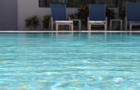 Surface level of swimming pool with pool chairs 