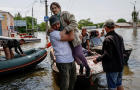 Volunteers evacuate local residents from a flooded area after the Nova Kakhovka dam breached, in Kherson 