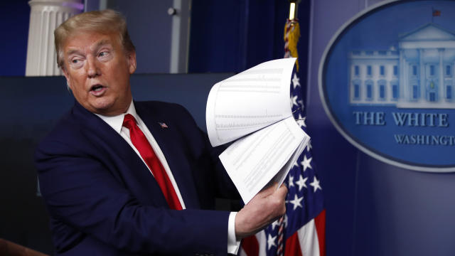 President Donald Trump holds up papers as he speaks about the coronavirus in the James Brady Press Briefing Room of the White House on April 20, 2020, in Washington. 
