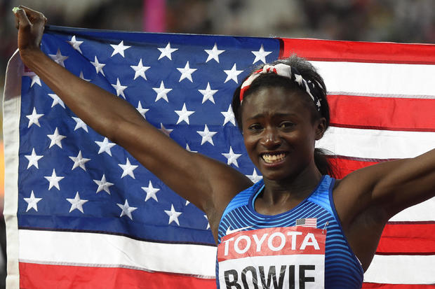 Tori Bowie holds an American flag after winning a world championship race 