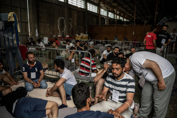 Rescued migrants sit inside a warehouse in Kalamata, Greece on June 15, 2023. 