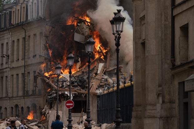 Smoke billows from rubble of a building in Paris after an apparent gas explosion