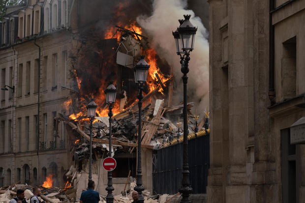 Smoke billows from rubble of a building in Paris after an apparent gas explosion 