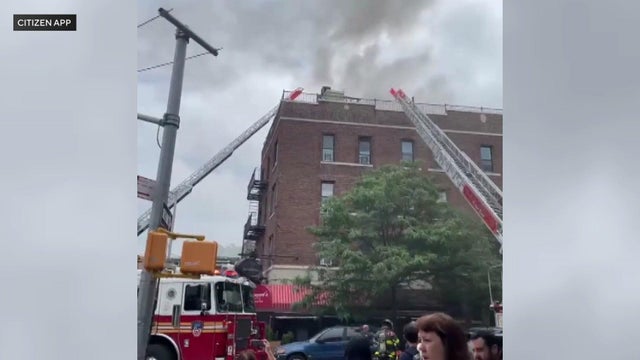 Smoke can be seen rising from the roof of a building Brooklyn. 
