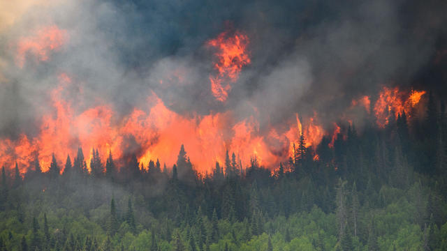 Flames reach upwards along the edge of a wildfire as seen from a Canadian Forces helicopter in Quebec 