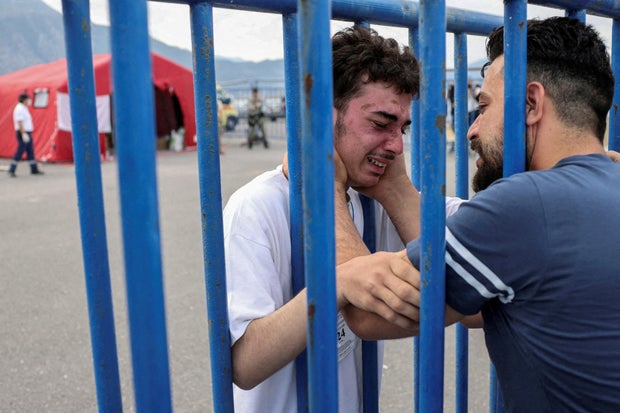 Syrian survivor Mohammad, 18, who was rescued with other refugees and migrants off Greece after their boat capsized, cries as he reunites with his brother Fadi, who came to meet him from Netherlands, at the port of Kalamata, Greece, on June 16, 2023.