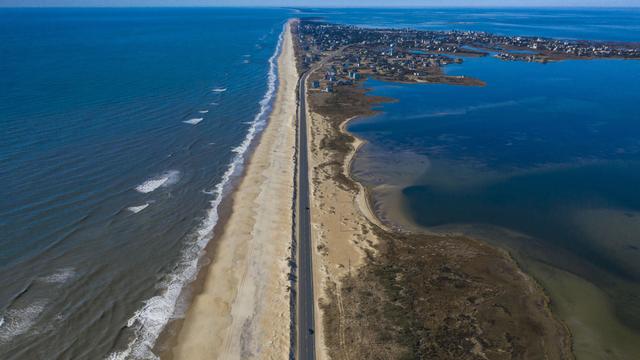 Drone aerial view of Outer Banks Highway 12 with Atlantic Ocean and Sound on both sides, Cape Hatteras National Seashore 