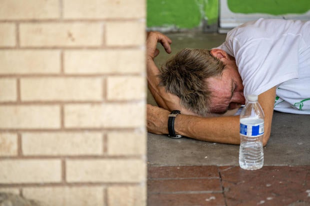 A person sleeps outside in the shade during a heat wave in Phoenix 