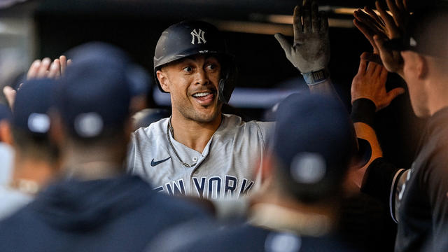 New York Yankees designated hitter Giancarlo Stanton (27) celebrates with teammates in the dugout after hitting a second inning three-riun home run during a game between the New York Yankees and the Colorado Rockies at Coors Field on July 15, 2023 in Denv 