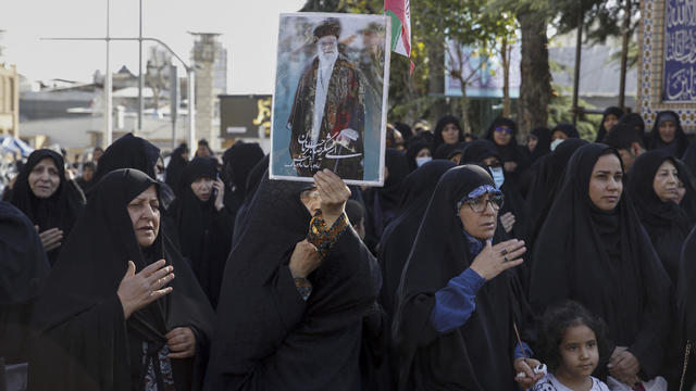 Iranian women lift a portrait of Supreme Leader Ayatollah Ali Khamenei as they take part in a pro-government rally in Tajrish square north of Tehran, on October 5, 2022. 
