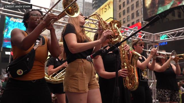 Members of Brass Queens perform on stage in Times Square. 