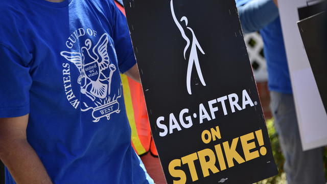 WGA member holding SAG-AFTRA strike sign 