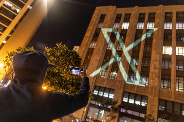 Twitter's new logo is seen projected on the corporate headquarters building in downtown San Francisco, California