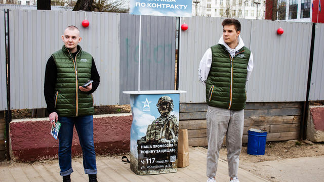 Two volunteers operate a mobile army recruitment spot set up 
