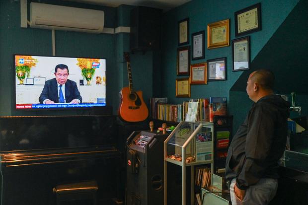 A man watches as Cambodia's Prime Minister Hun Sen speaks during a special statement on television at a restaurant in Phnom Penh on July 26, 2023. 