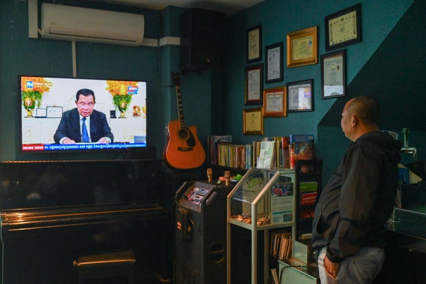 A man watches as Cambodia's Prime Minister Hun Sen speaks during a special statement on television at a restaurant in Phnom Penh on July 26, 2023.