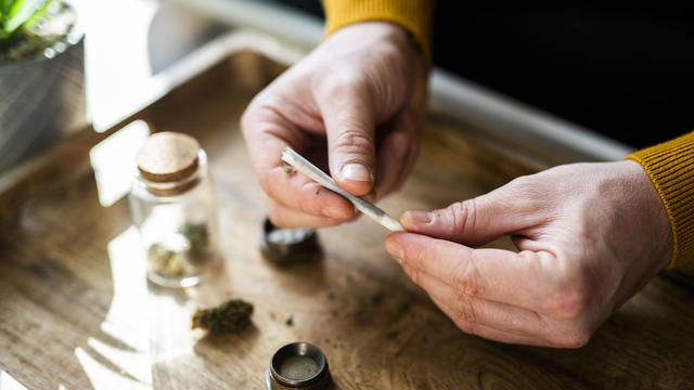 Close-up of a man's hands preparing a joint of marijuana. 