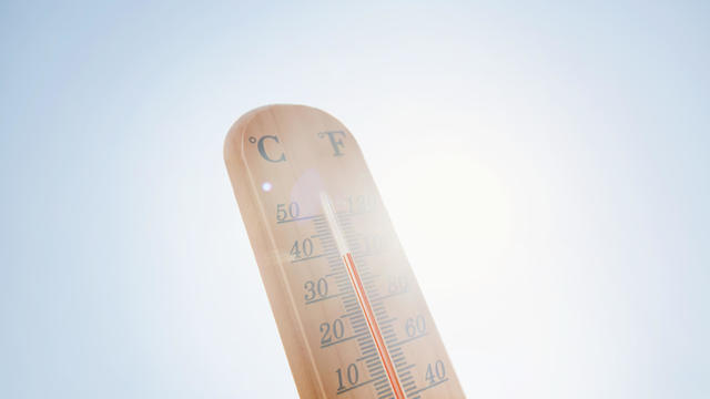 Thermometer against sky and sun 