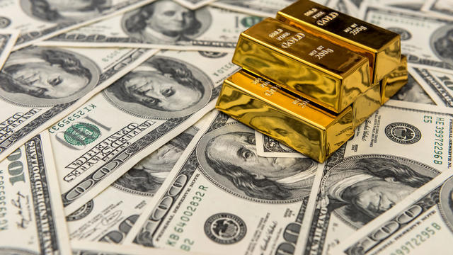 gold bullion bars on usd money bills. Success concept 
