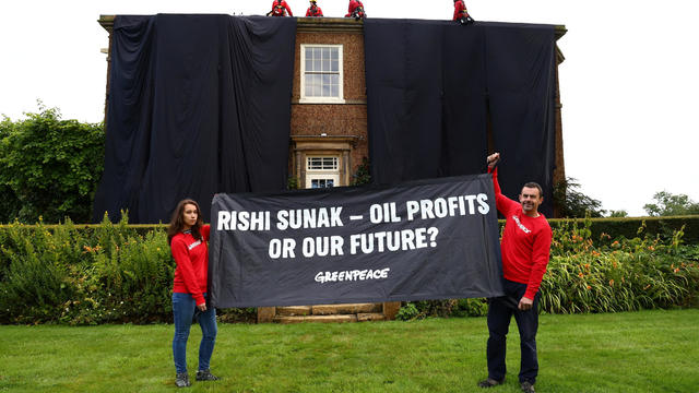 Climbers cover Rishi Sunak's mansion in oil-black fabric 