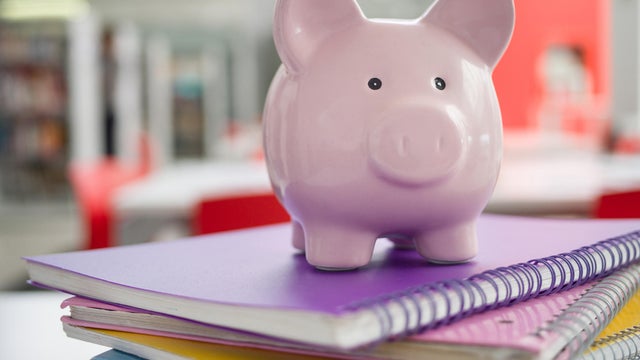 Pink piggy bank on top notebooks - Student loans 