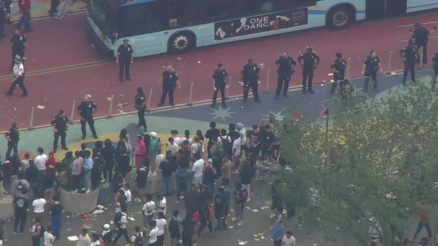 An aerial view of thousands of people crowded into Union Square. A line of police officers stand in the street.