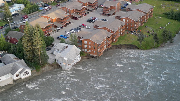 A drone view shows a house before it collapses into a river due to glacial floods in Juneau 