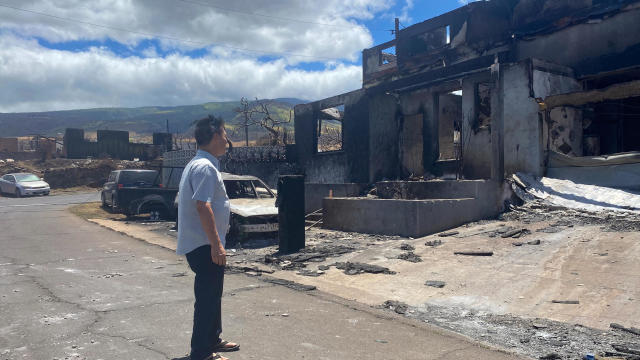 Burned cars sit in front of an apartment building that was destroyed by a wildfire in Maui 