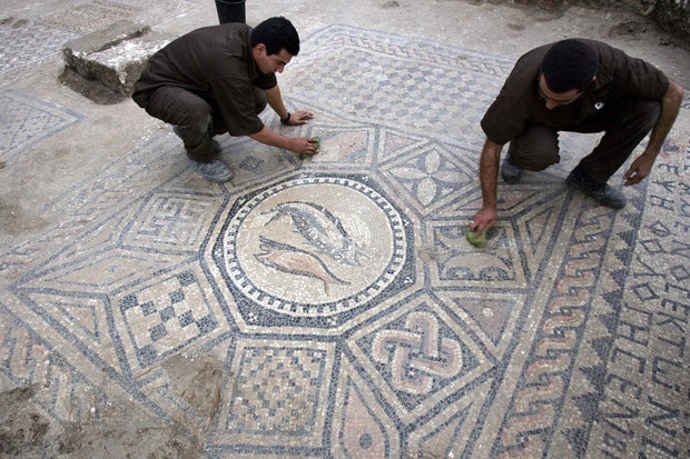 Israeli prisoner clean an early Christian mosaic of a recently excavated church from the 3rd-4th centuries AD, 06 November 2005