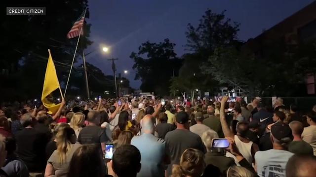 Hundreds of people flood a street on Staten Island. 