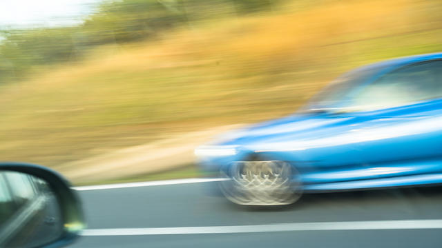 A car is traveling at high speed on the road. Shaken image. 