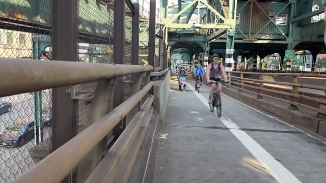 Cyclists travel along the Queensboro Bridge pathway. 