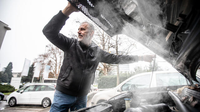 Steam Coming Out of Car Engine While Mature Man is Opening the Hood 