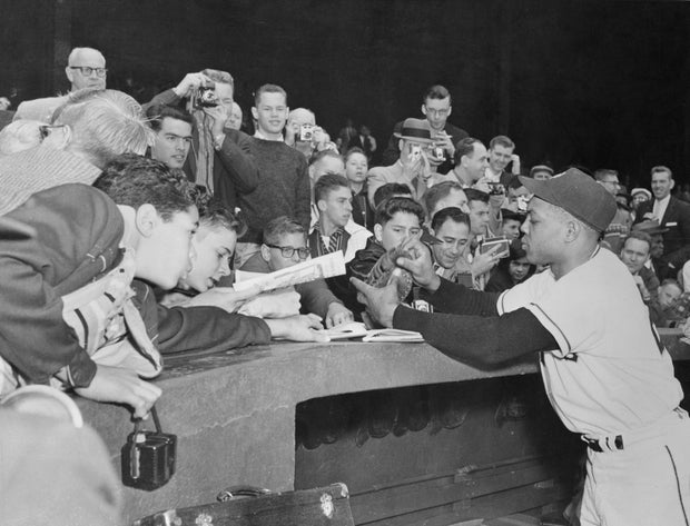 Willie Mays signing an autograph for fans