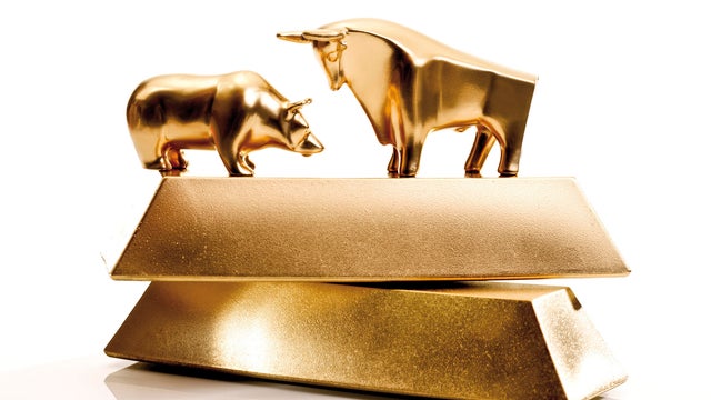 Bull and bear sculptures by gold bars 